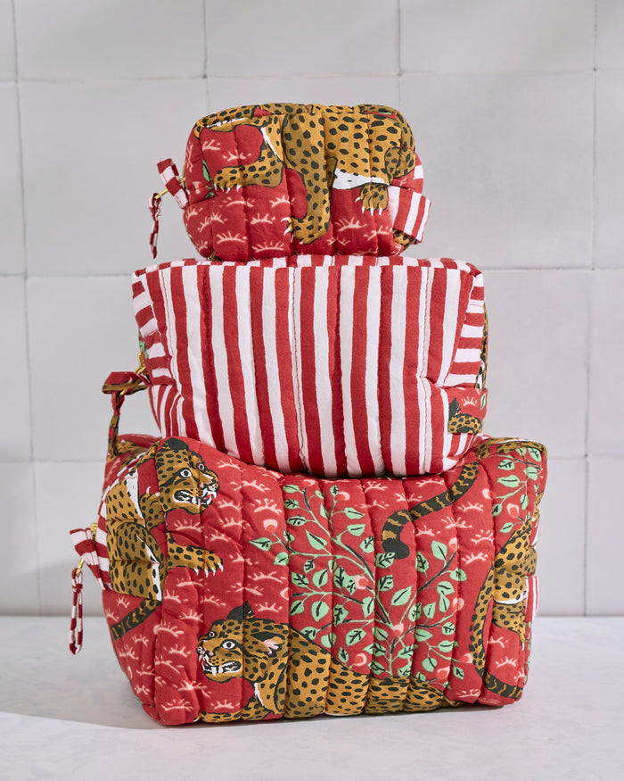 Three stacked quilted Bagheera pouches in red, leopard, green, and red-and-white striped prints.