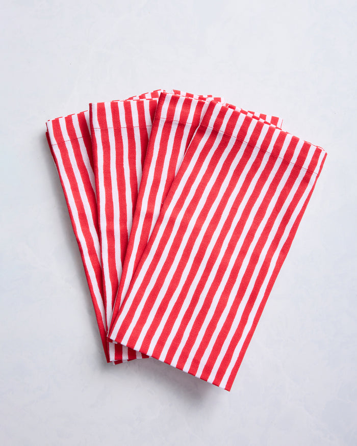 Four folded dinner napkins with red and white painted stripes